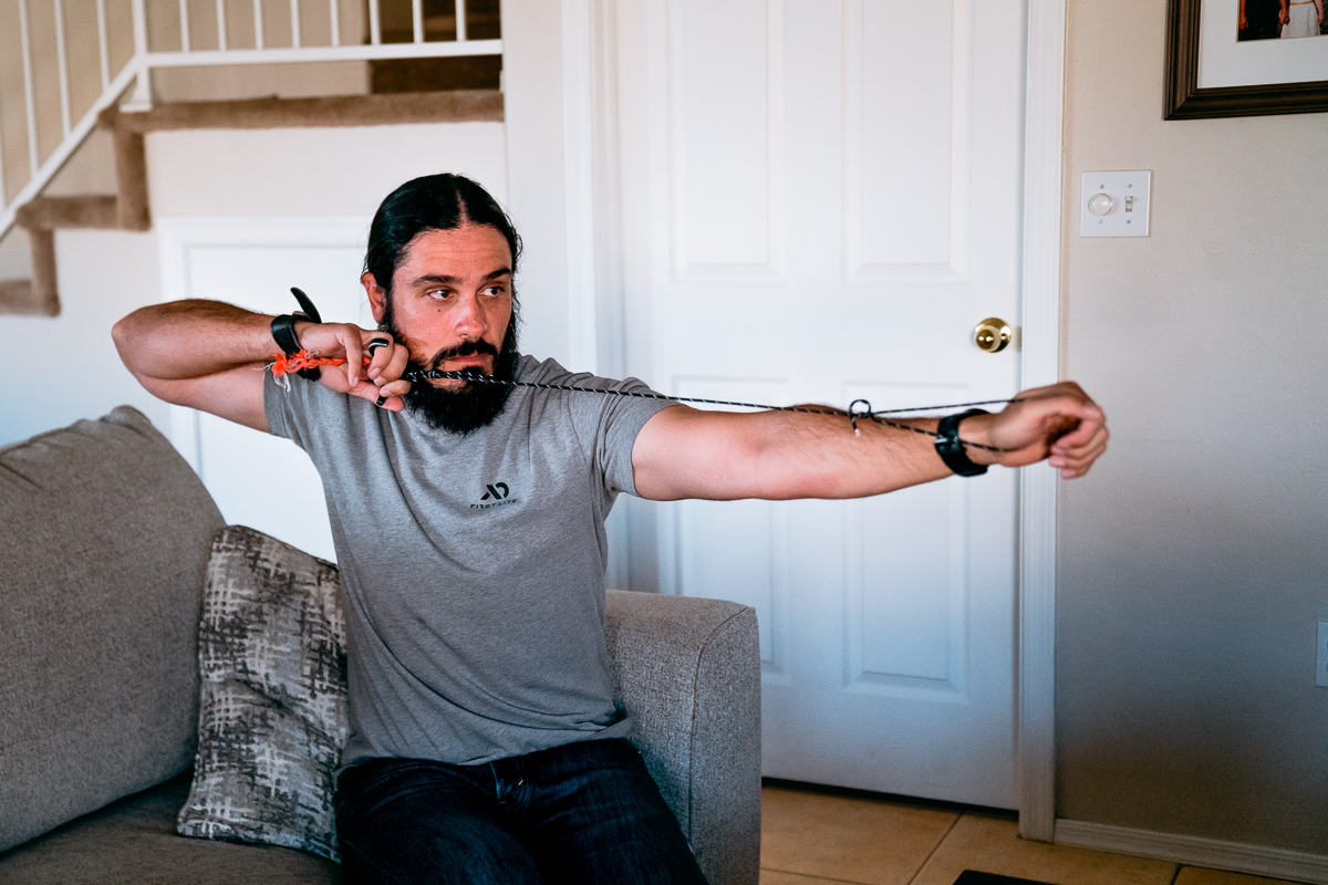 Josh Kirchner from Dialed in Hunter practicing his archery release on the couch with paracord