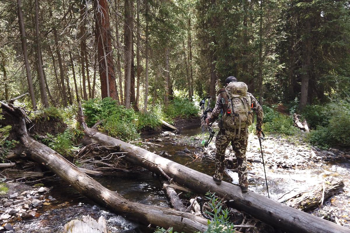 Eric Voris crossing a creek in the backcountry